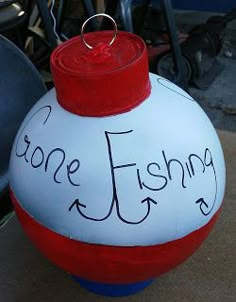 a red, white and blue ball with the words gone fishing written on it sitting next to other items