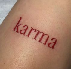 the word karma written in red ink on someone's leg, with an arrow