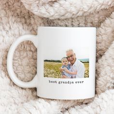 a white coffee mug with the words best grandma ever printed on it next to a blanket