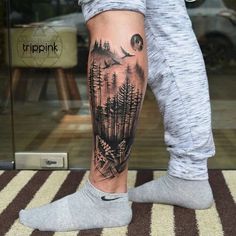 a person with a forest tattoo on their leg