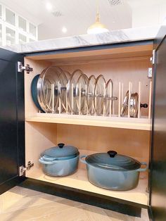 two pots and pans are sitting on the shelves next to each other in this cabinet