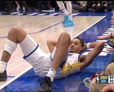 a basketball player laying on the floor with his feet up