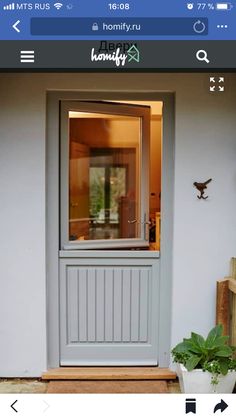 the front door to a house with a potted plant next to it and an open window