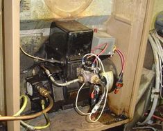 the inside of an old furnace with wires and other electrical equipment on top of it