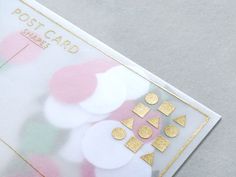 a close up of a post card with gold foil on it and pink, white and green circles