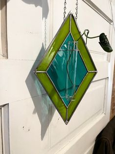 a green stained glass hanging from a door