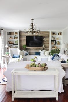 a living room filled with furniture and a flat screen tv mounted to the side of a wall