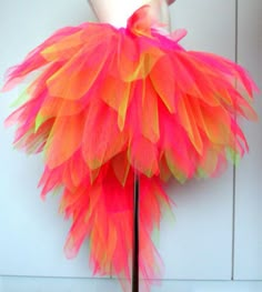 an orange and pink feathered skirt on a mannequin