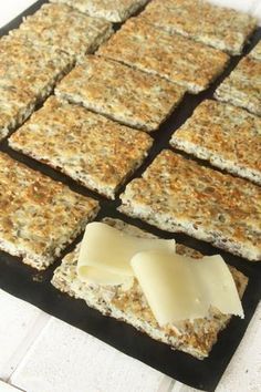 crackers and cheese are laid out on a baking sheet