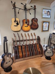 acoustic guitars on stand and hanging from the wall Family Music Room, Bass Guitar Stand, Guitar Mount, Wooden Guitar Hanger, Guitar Decorations, Multiple Guitar Stand, Wood Guitar Stand, Wooden Guitar Stand, Guitar Storage