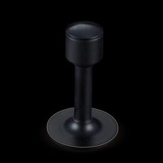 a black object with a metal base on a black background