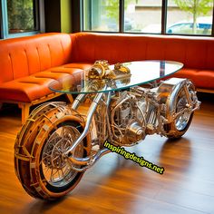 a glass table sitting on top of a wooden floor in front of a motorcycle engine