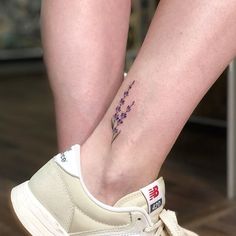 a close up of a person's foot with a flower tattoo on the ankle