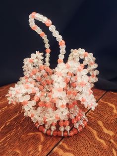 a vase filled with lots of beads on top of a wooden table