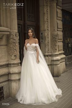 a woman in a wedding dress standing outside