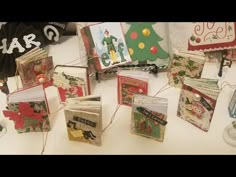 many christmas cards are sitting on a table with string attached to the top of them