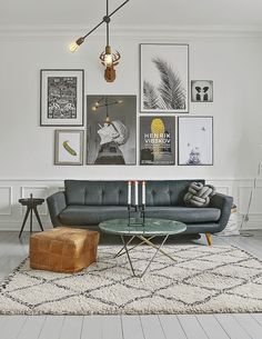 a living room filled with furniture and pictures hanging on the wall above it's coffee table