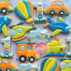 decorated cookies with cars, trucks and planes are displayed on a blue tablecloth that says let's mante