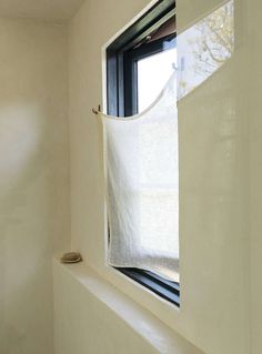 a white curtain hanging from the side of a window