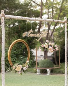 an arch with flowers hanging from it and the word always written on it in gold