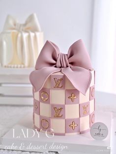 a pink and white box with a bow on it's side sitting on a table