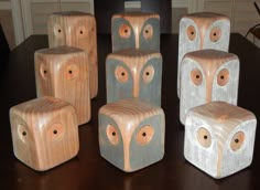 five wooden blocks with eyes on them sitting on a table in front of a chair