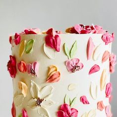 a close up of a white cake with flowers on the frosting and icing