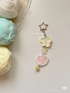 a crochet keychain with two balls of yarn and a star on it