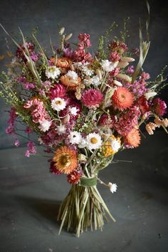 a vase filled with lots of different colored flowers