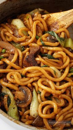 stir fried noodles with mushrooms and vegetables in a pot