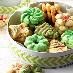 a white bowl filled with green and red sprinkle cookies on top of a table