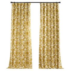 an open curtain with yellow flowers on it and black metal rods in front of the window