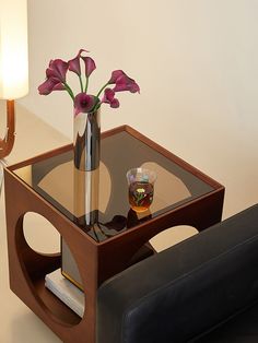 a glass table with a vase and flowers on it