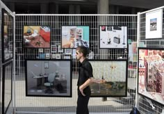 a man is walking in front of several art work on display at the same time