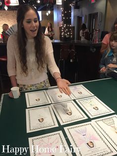 a woman standing at a table with lots of cards on it