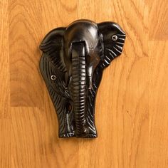 an elephant's head is mounted on a wooden wall with wood grain flooring