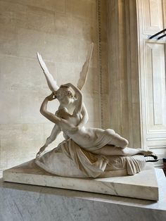 a statue of a woman laying on top of a marble slab