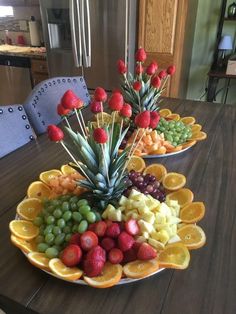 two plates filled with fruit on top of a wooden table