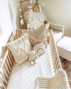 a baby crib with pillows and stuffed animals on the bed in front of it