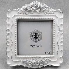 an ornate white frame with a fleur de lis design on the front and bottom