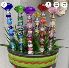 a pot filled with lots of different colored glass beads and plants in front of a door