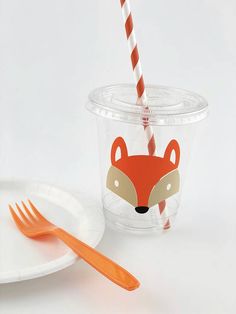 a plastic cup with an orange and white striped straw in the shape of a fox