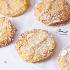 powdered sugar cookies sitting on top of a white paper