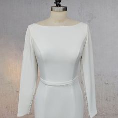 a white dress on a mannequin dummy with an open back and long sleeves