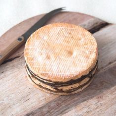 a stack of wooden slices sitting on top of a cutting board next to a knife