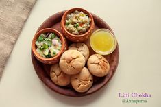 small bowls filled with food sitting on top of a wooden plate next to a cup