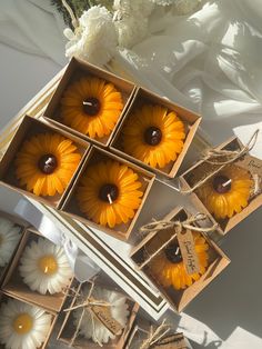 four sunflowers are in small boxes on the table