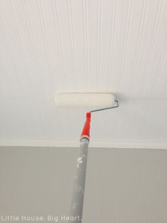 a paint roller is attached to the ceiling in a room with white walls and ceilings