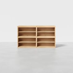 an empty wooden bookcase sitting on top of a cement floor