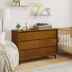 a baby's room with a dresser and crib